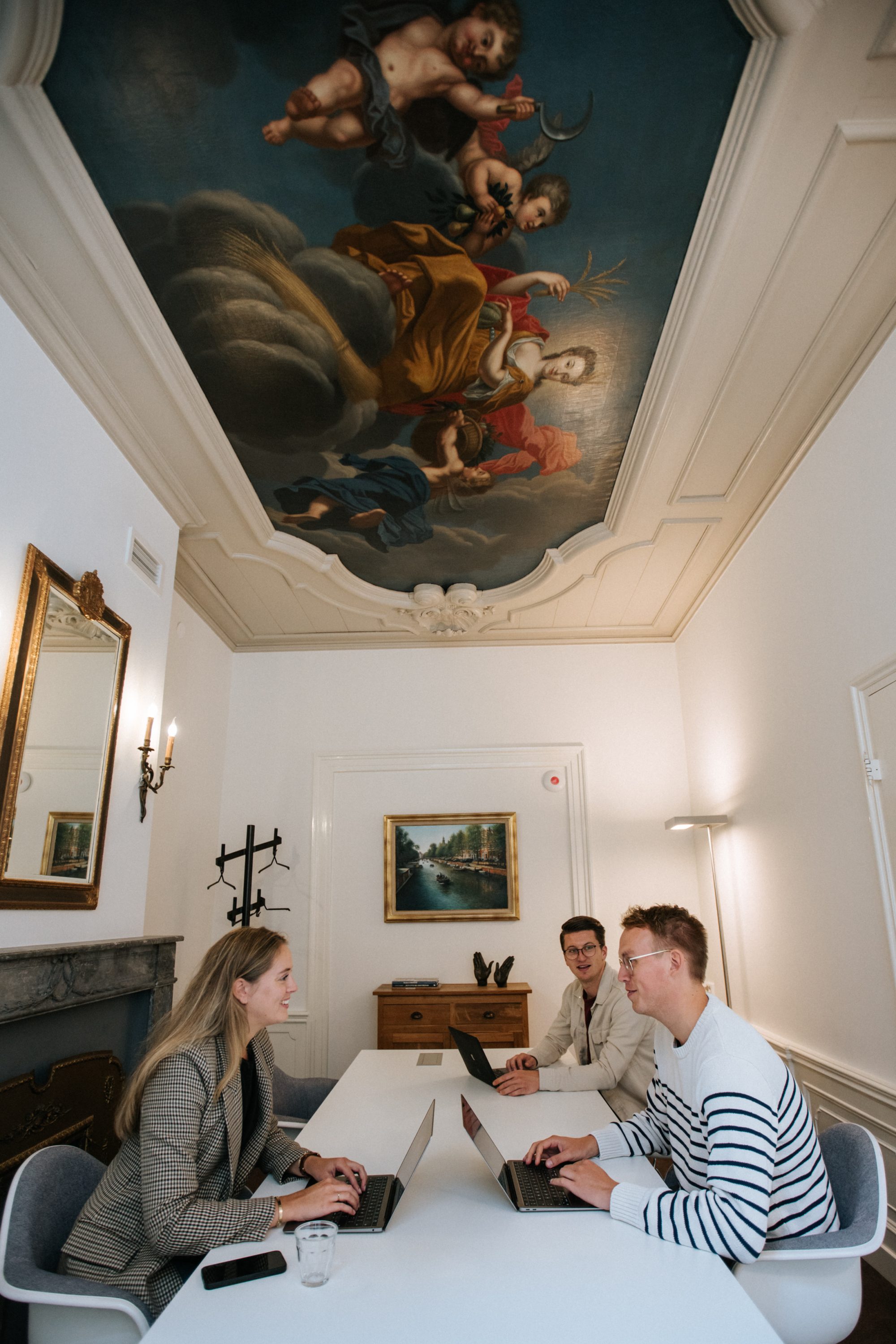 Exclusieve vergaderruimte in Amsterdam met historische plafondschildering en moderne werkplekken bij EBC aan de Herengracht.